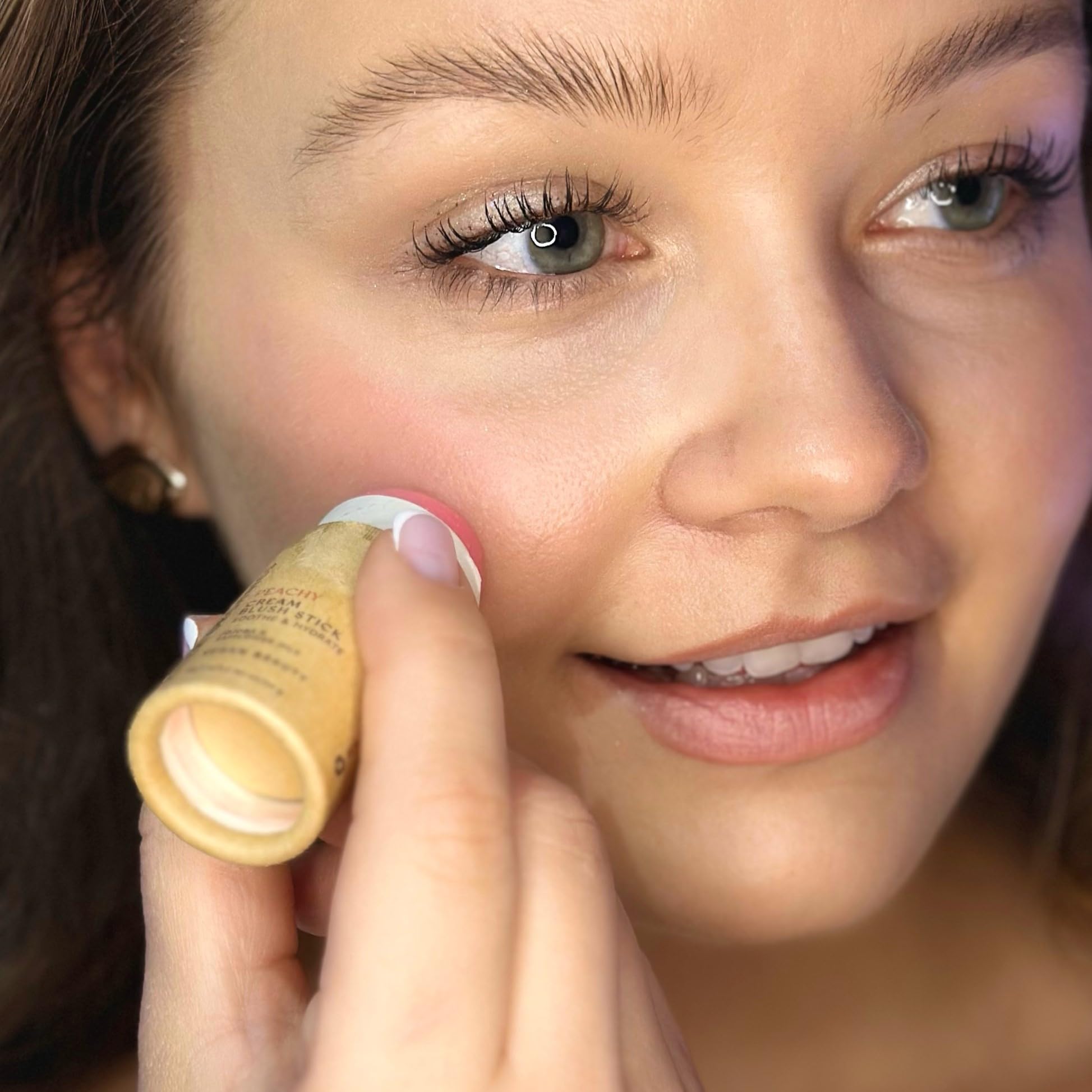 River Organics Peachy blush on cheeks for natural, radiant glow.