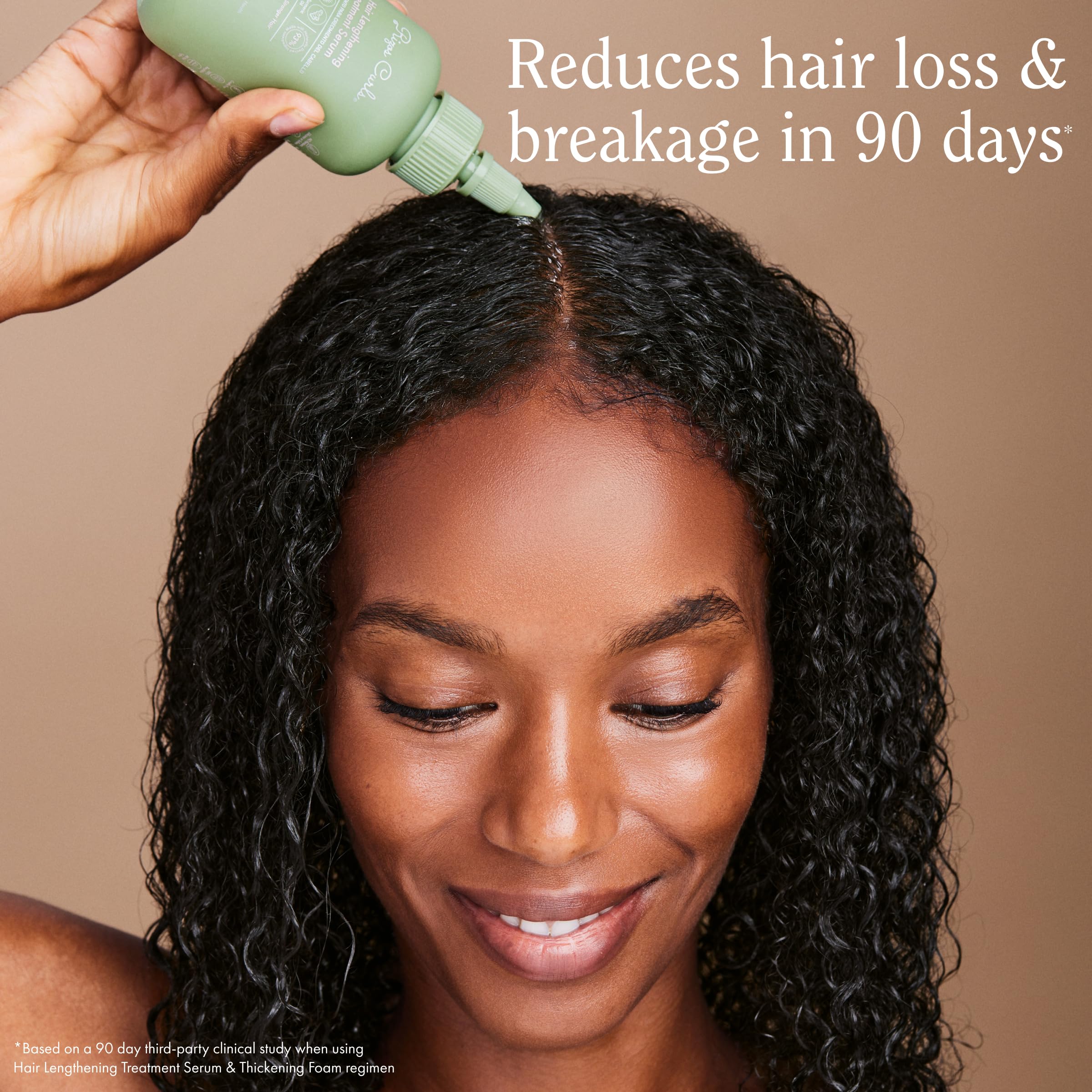 Rizos Curls applying serum to the scalp for targeted nourishment.