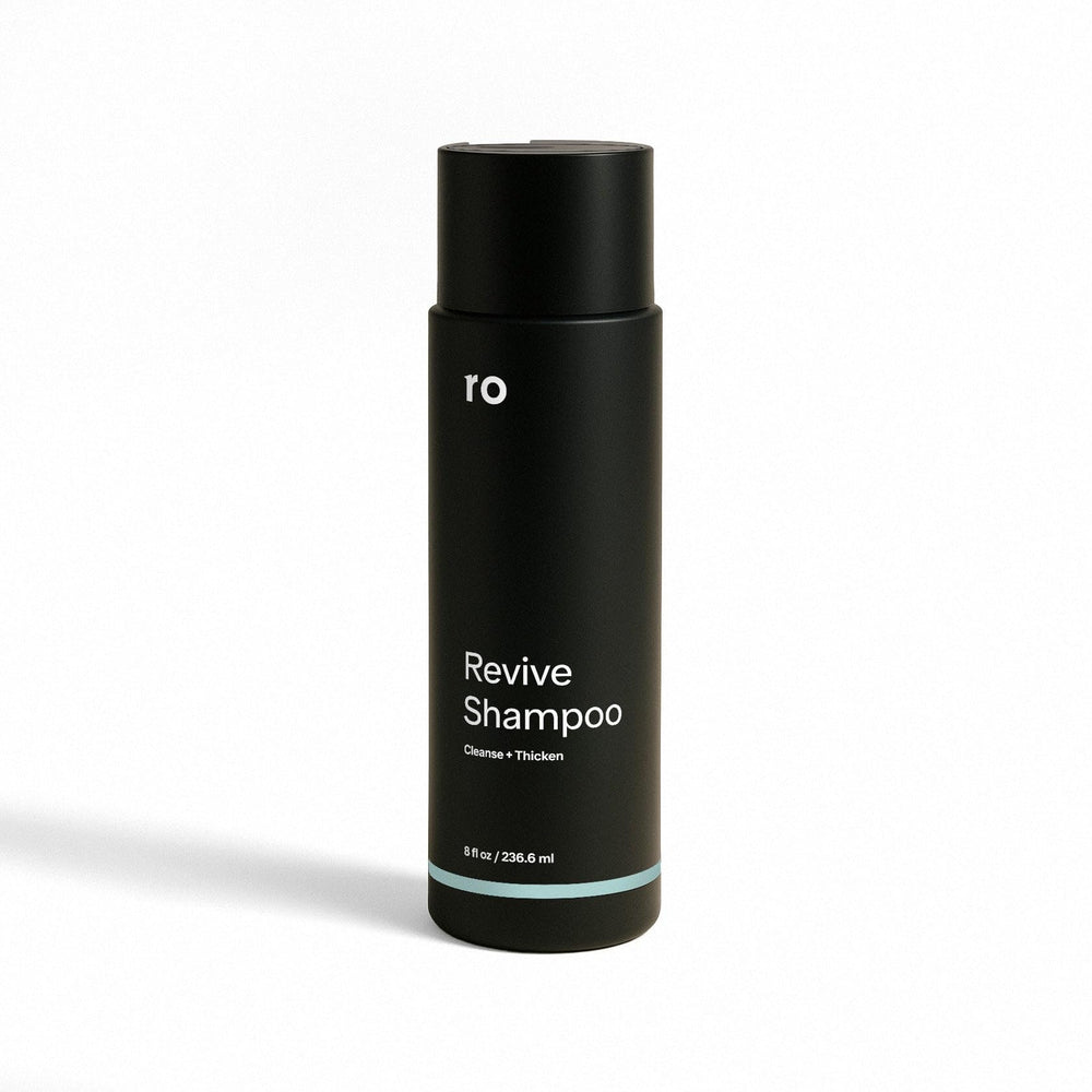 Ro Men's Revive Shampoo bottle pouring for a refreshing cleanse and fuller-looking hair.