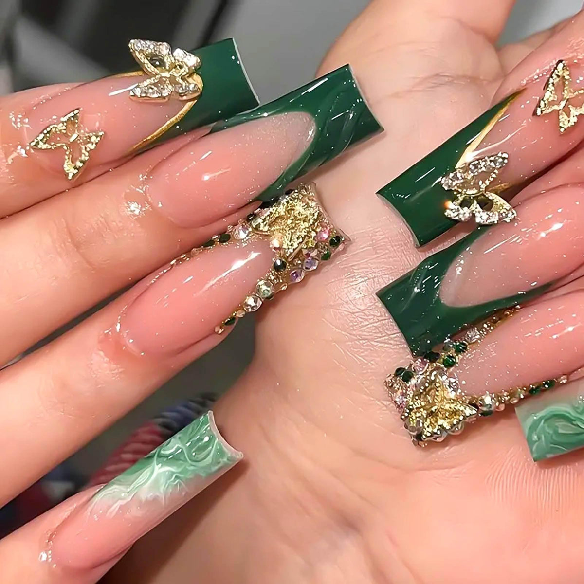 RUOKEXIN green French tip nails with gold glitter butterflies for a chic look.