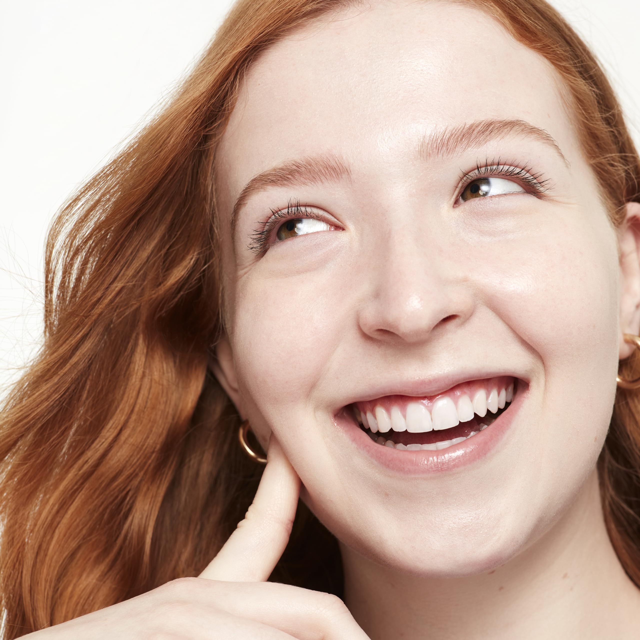 Application on fingertip shows Saie Glowy Super Skin Tint coverage.