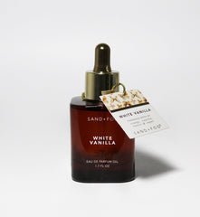 Sand + Fog White Vanilla perfume oil application—precise dab for refined fragrance layer.
