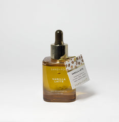 Sand + Fog Vanilla Latte EDP Oil bottle showing warm gourmand notes and amber glow.