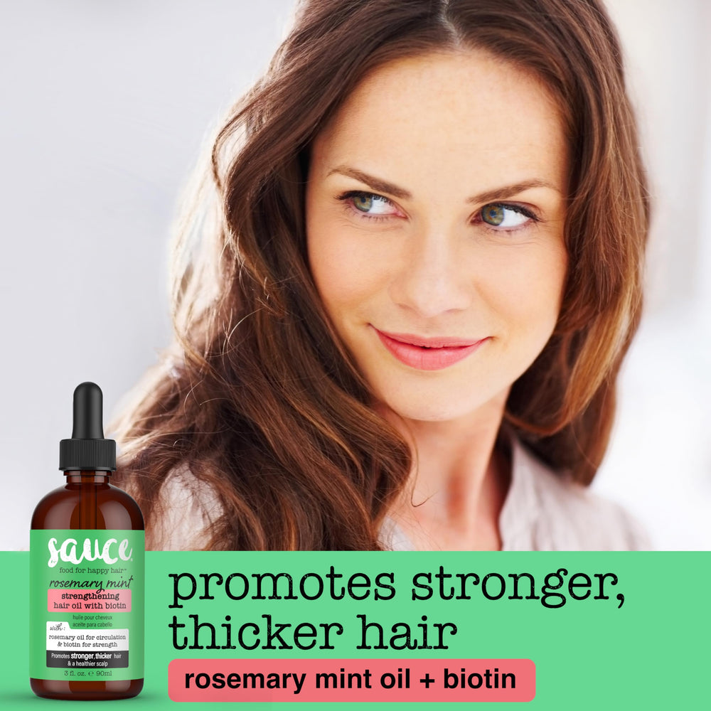 Sauce Beauty Rosemary Mint Hair Oil label close-up highlighting biotin for hair nourishment.