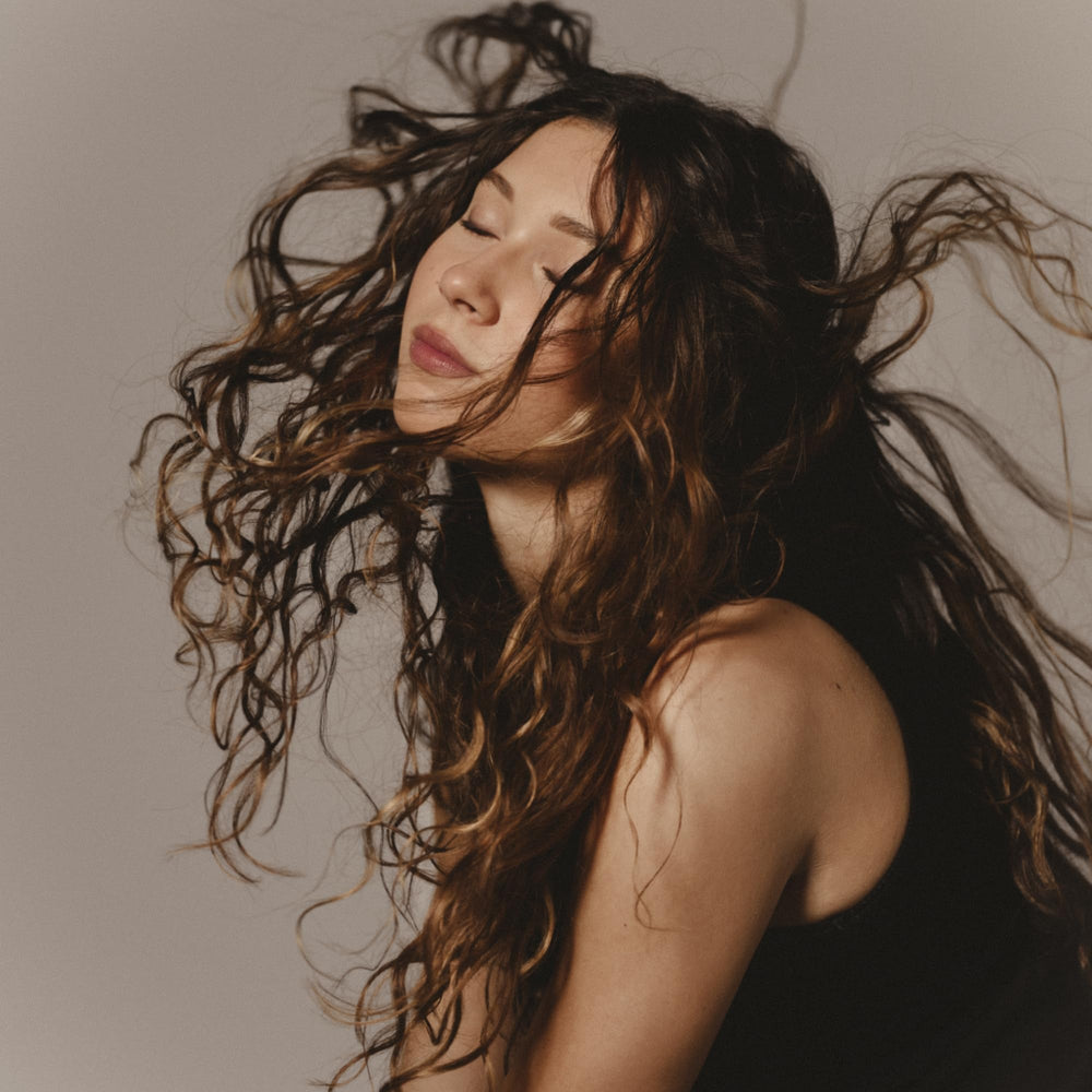 Close-up of defined curls with Sisley Paris Curl Care Jelly's glossy finish.