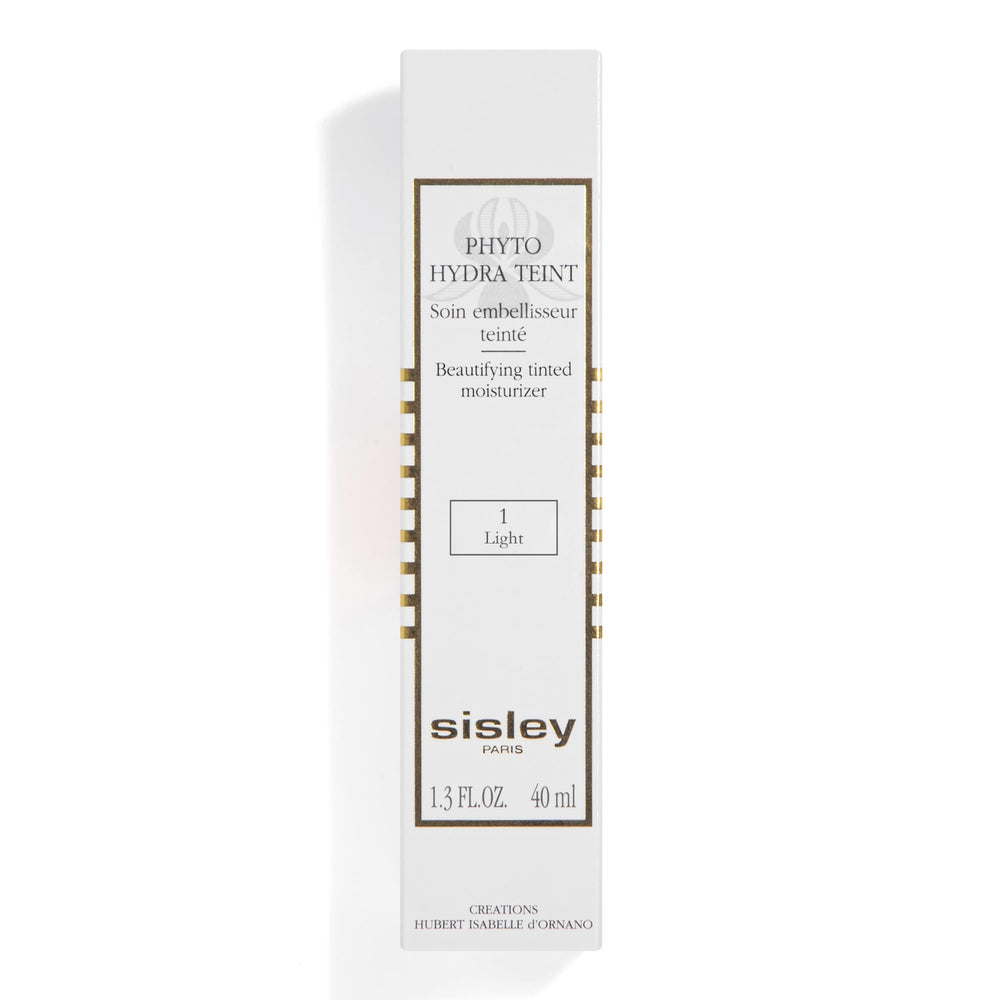 Sisley Paris Phyto-Hydra Teint bottle resting on vanity with soft lighting.