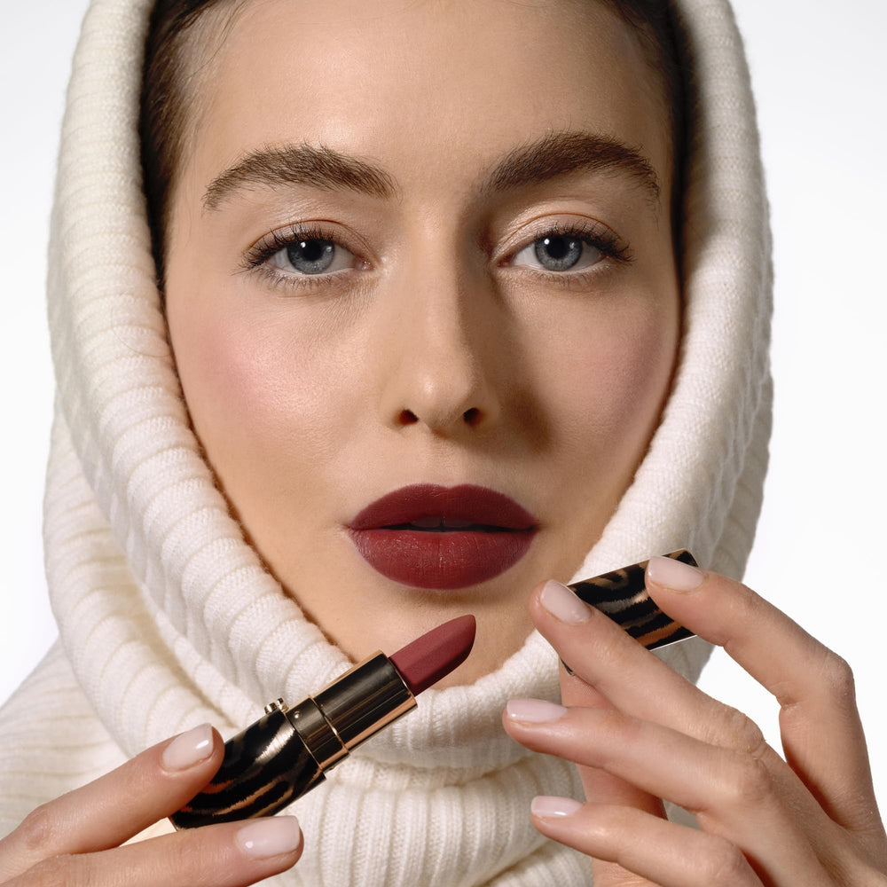 Application close-up of Sisley Paris Phyto-Rouge Velvet orange fawn reveals creamy glide.