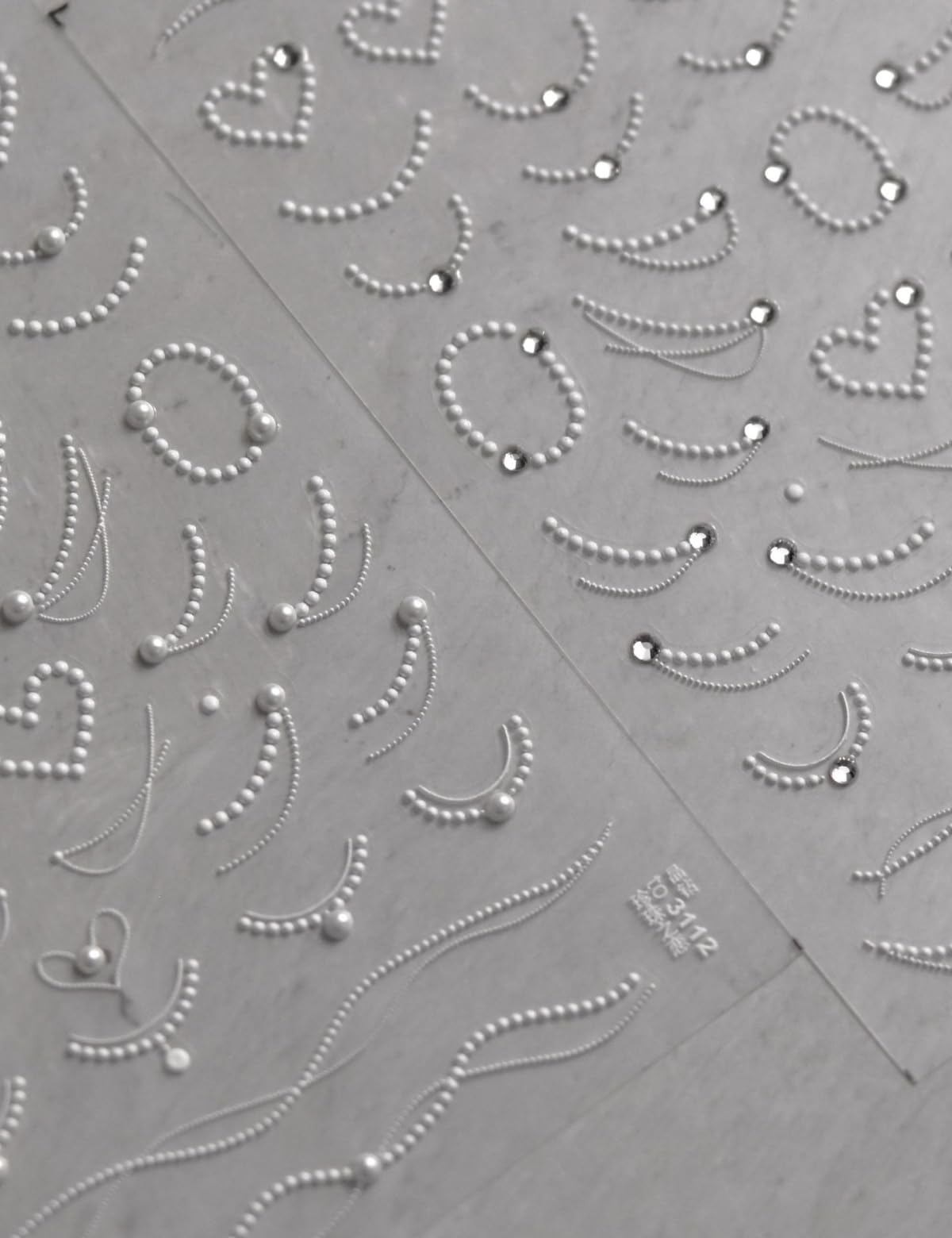 SOFTSOUL embossed pearl chains detail adds textured elegance to manicures.