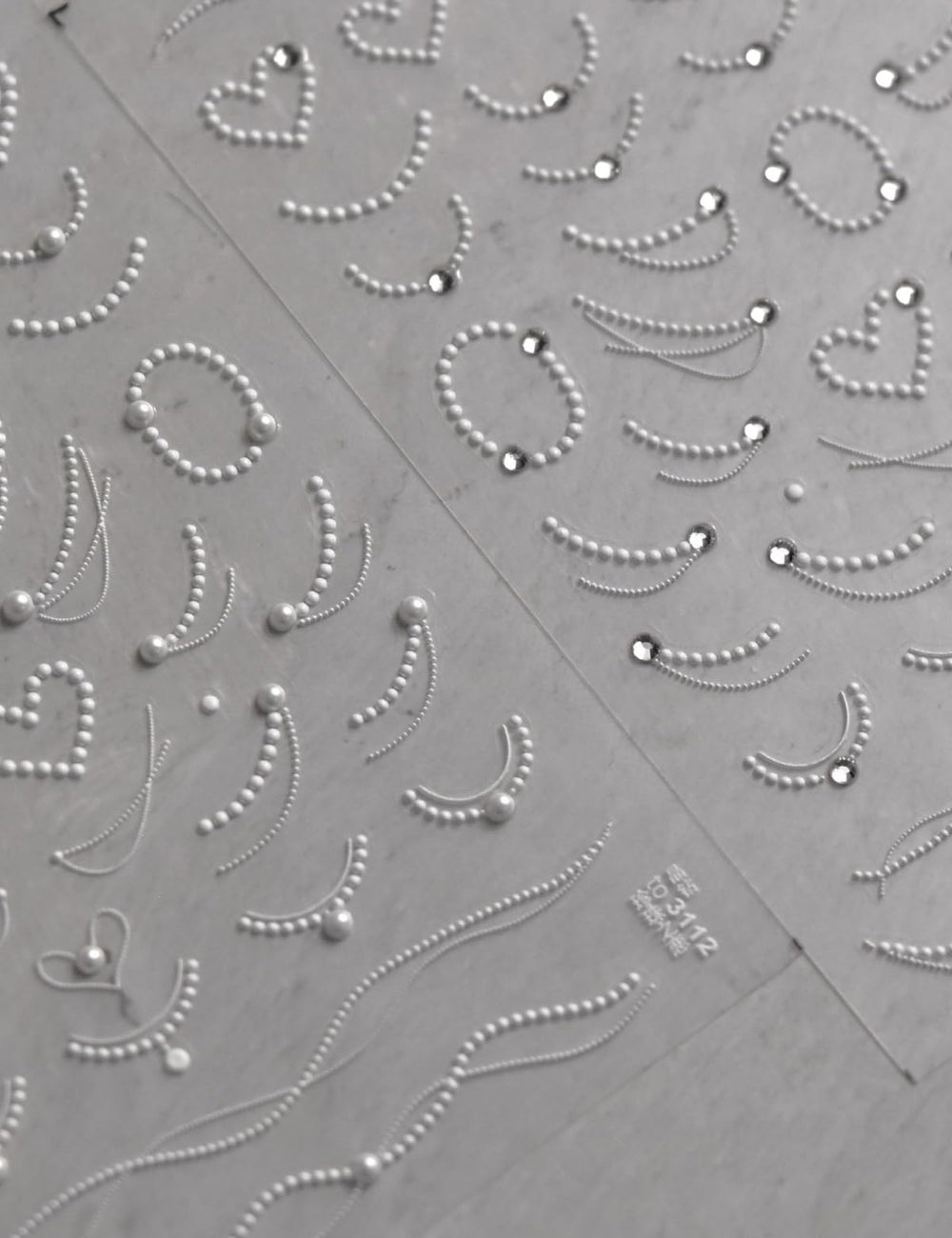 SOFTSOUL embossed pearl chains detail adds textured elegance to manicures.