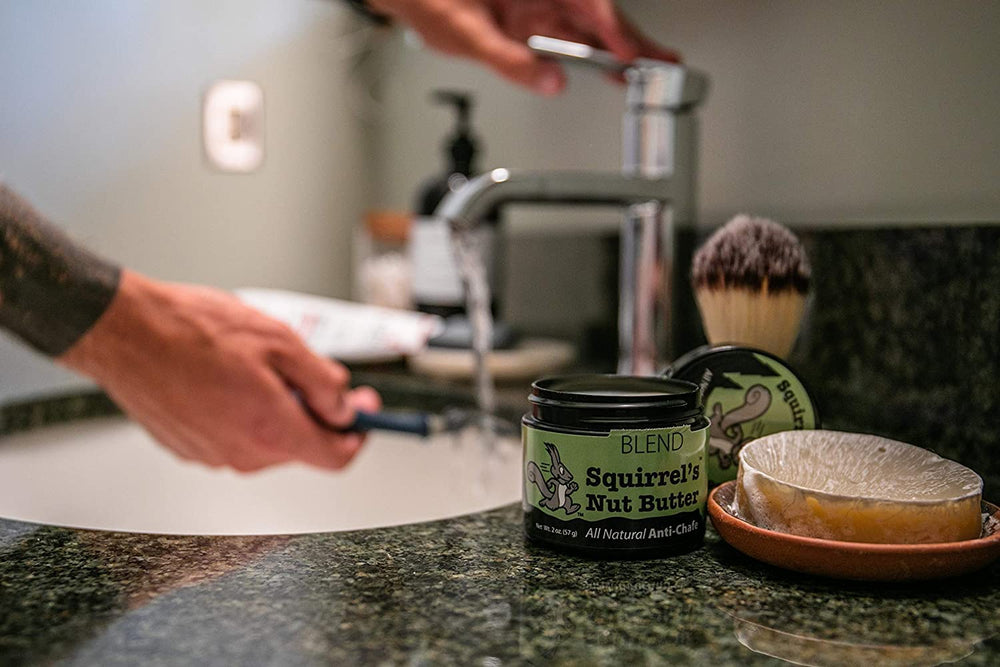 Squirrel's Nut Butter anti-chafe tub being applied to skin for comfort during activity