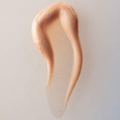 Hand applying Summer Fridays Illuminating Drops for quick radiant glow