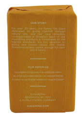 Sunaroma soap bar close-up shows creamy lather with shea butter.