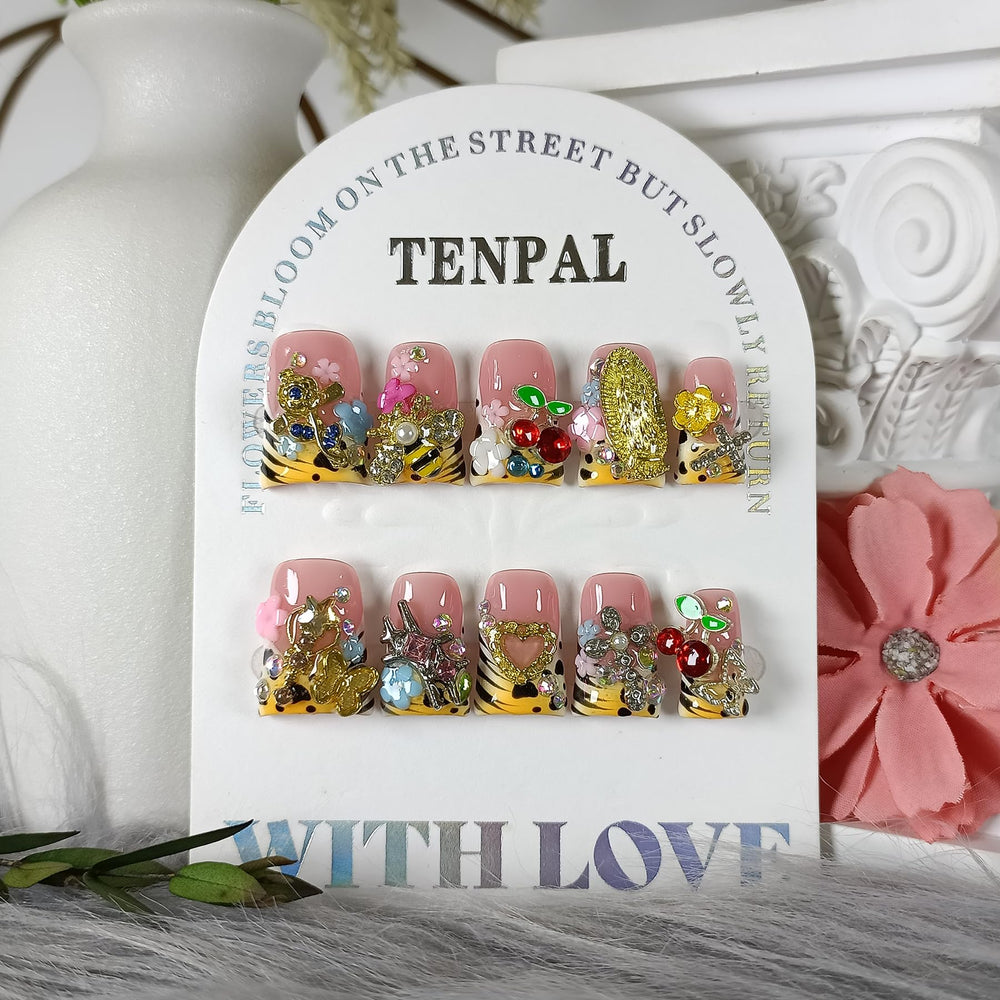TENPAL duckbill nails with pale-yellow French tip and 3D bee and fairy charms.