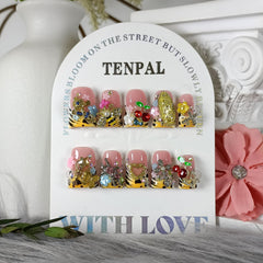 TENPAL duckbill nails with pale-yellow French tip and 3D bee and fairy charms.