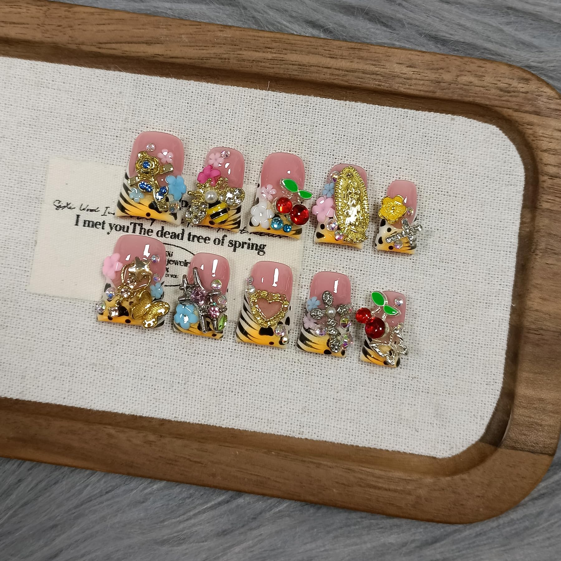 TENPAL close-up of 3D bee and fairy charms on glossy nails.