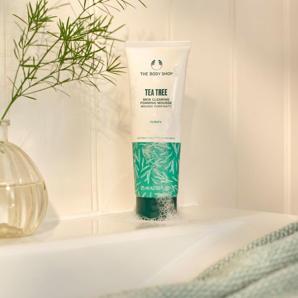 Closeup of Tea Tree cleanser bottle showing foamy action for blemish-prone skin.