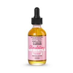 The Mane Attraction Hair Oil bottle on a reflective surface showing hydration potential