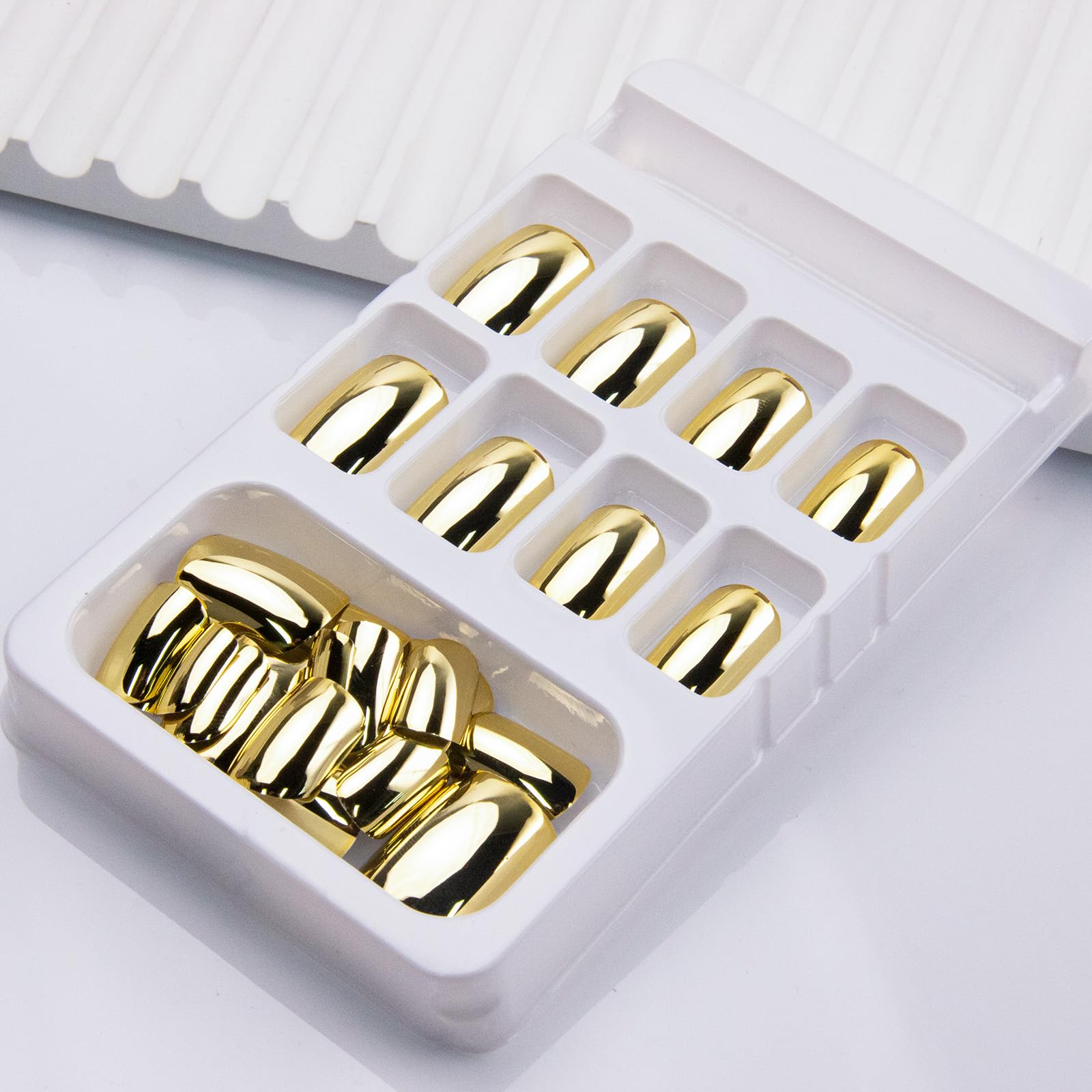 Thuoxde glossy gold nails on hand highlight radiant shine and polished style.