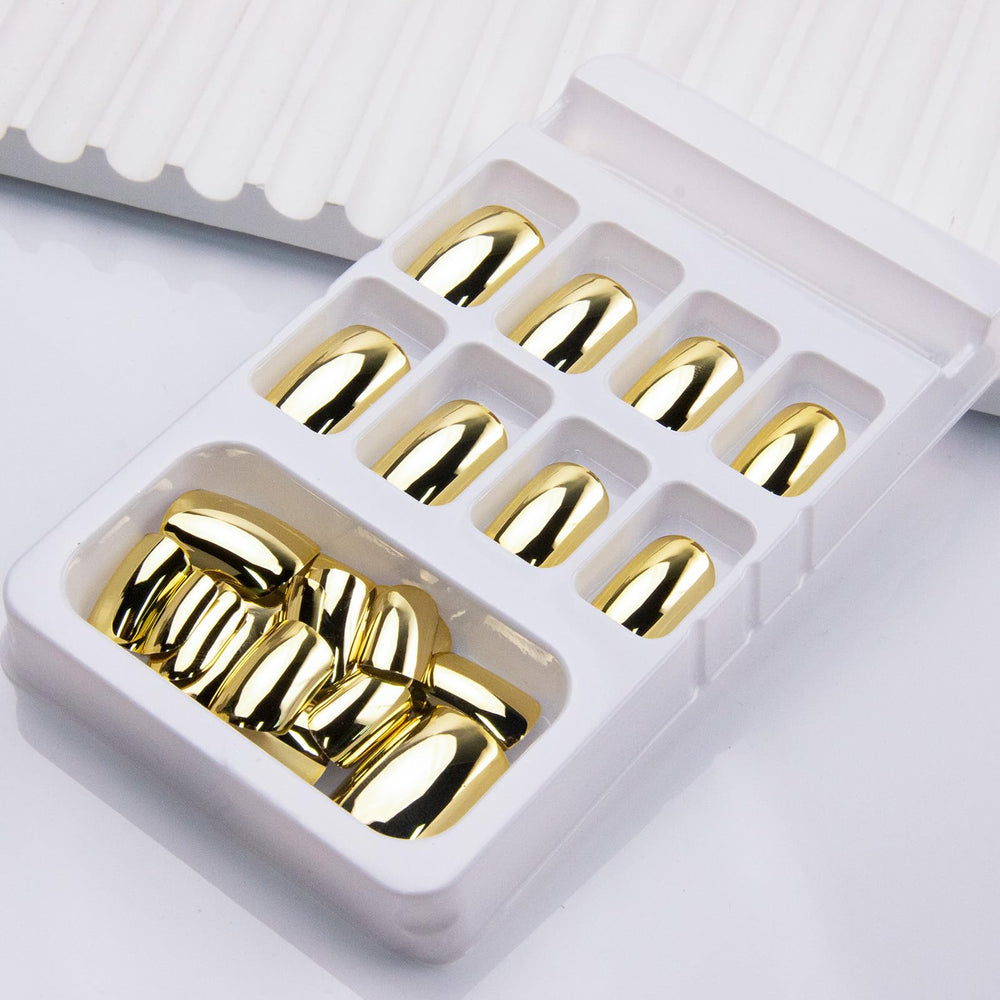 Thuoxde glossy gold nails on hand highlight radiant shine and polished style.