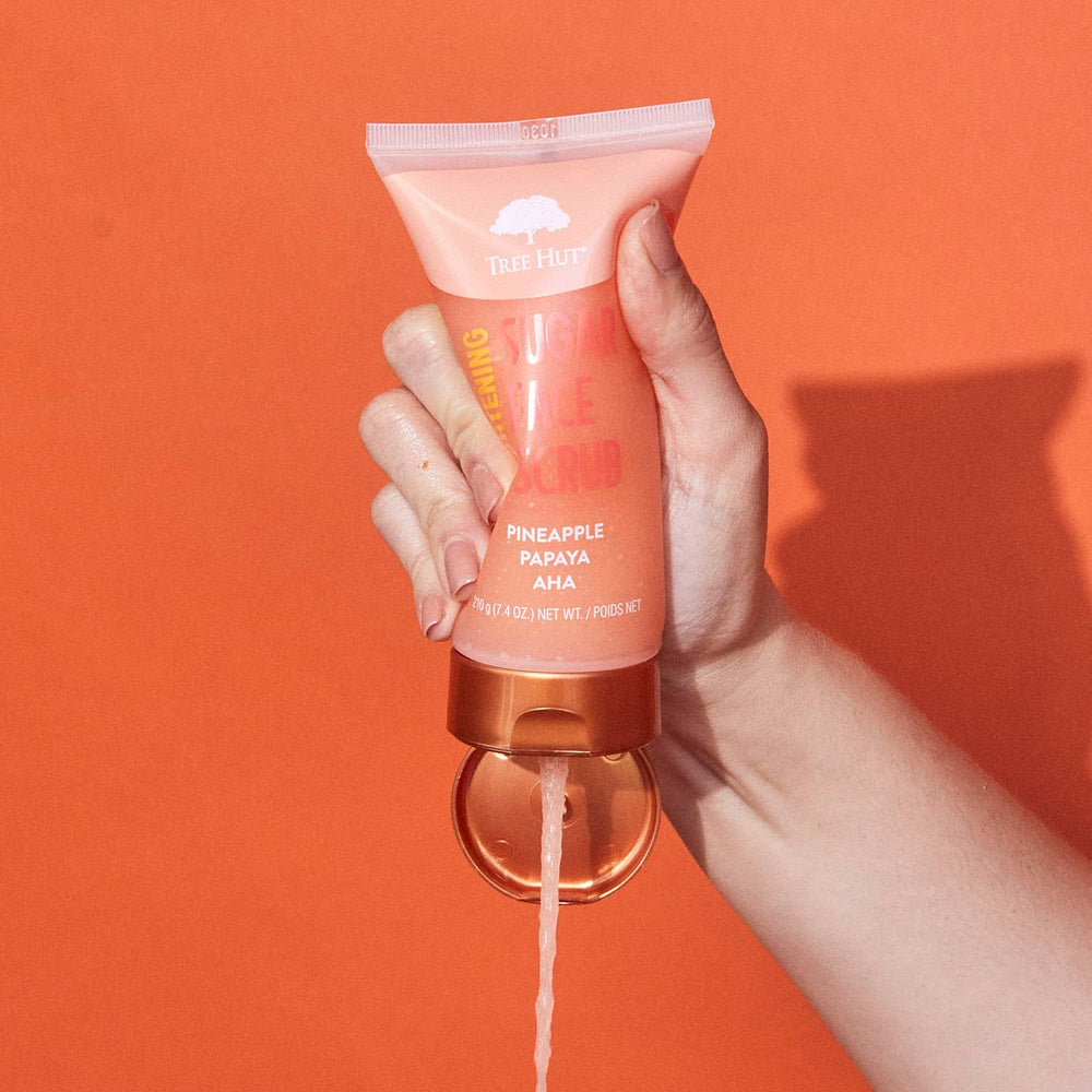 Product being poured from Tree Hut Pineapple Papaya Face Scrub for even application.