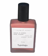 Typology Tinted Lip Oil Shade 2 Powder Pink on lips with nourishing shine.