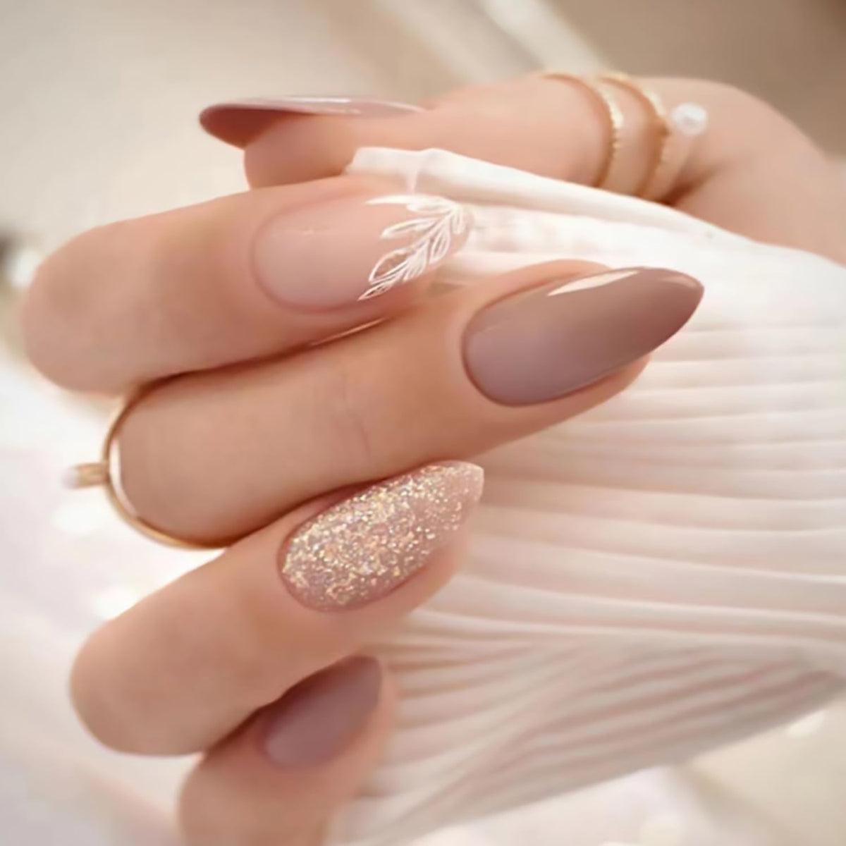 Tyuimhx leaf-design almond press-on nails in nude finish, showcasing elegant nail art.