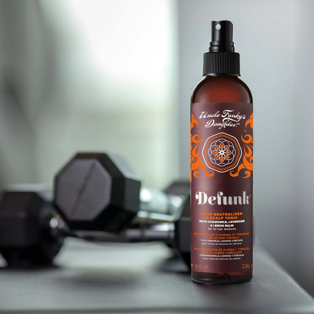 Defunk bottle being sprayed for odor control on hair.
