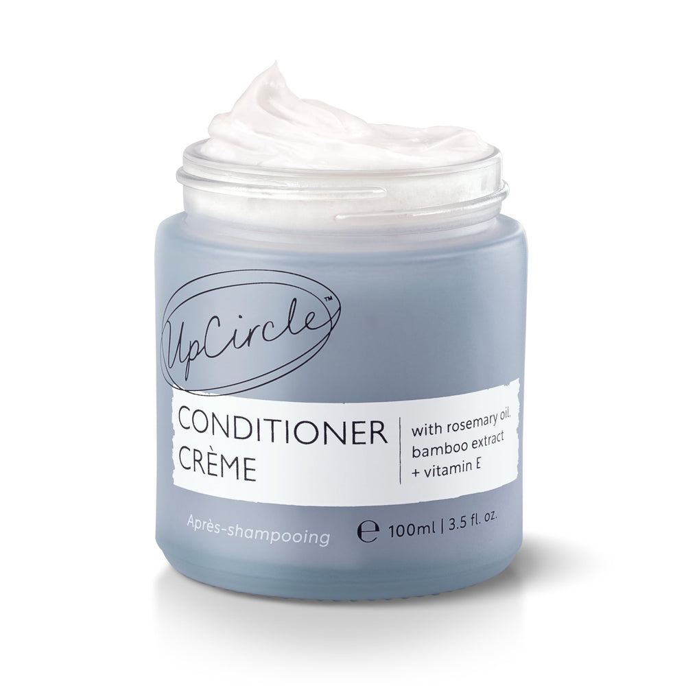 UPCIRCLE conditioner creme bottle highlights rosemary oil for gentle frizz control.