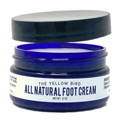 The Yellow Bird foot cream with tea tree oil in a jar delivers hydrating care.