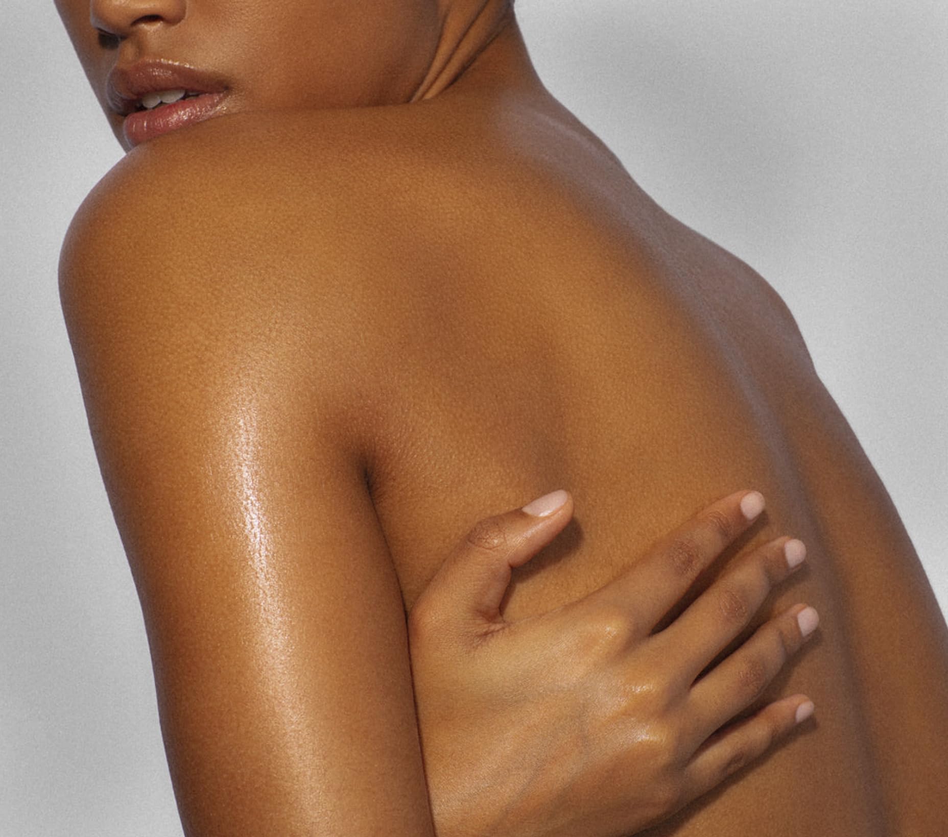 Yves Rocher Monoi Tahiti oil bottle close-up with subtle shimmer on skin.