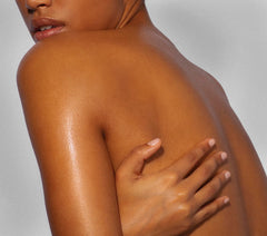 Yves Rocher Monoi Tahiti oil bottle close-up with subtle shimmer on skin.